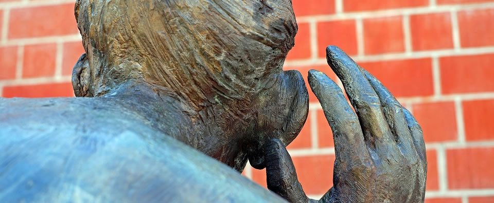 Wooden sculpture, a hand to the ear