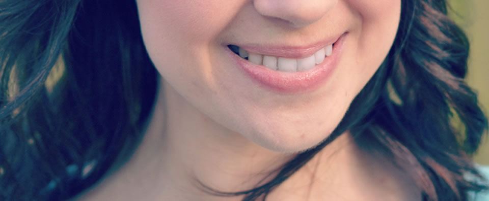 Smiling woman after lingual braces treatment at LLOC