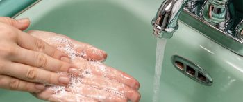 Wwashing hands in greens sink with running water