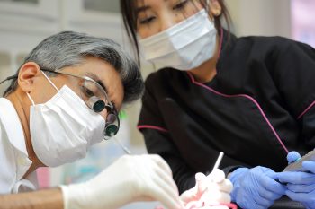 Dr Asif Chatoo at a bonding up procedure to fit braces with a member of his dental team