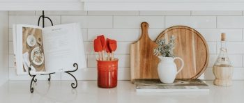 Kitchen worktop with cook book, utensils and chopping boards